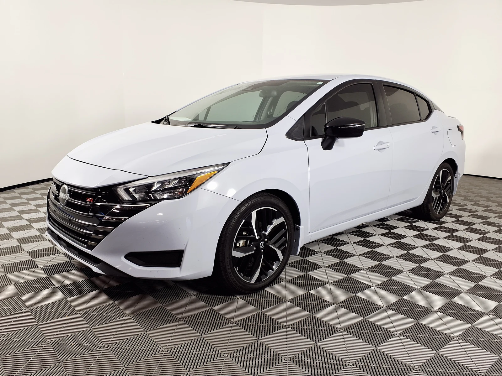Nissan Versa blanco, vista frontal y lateral